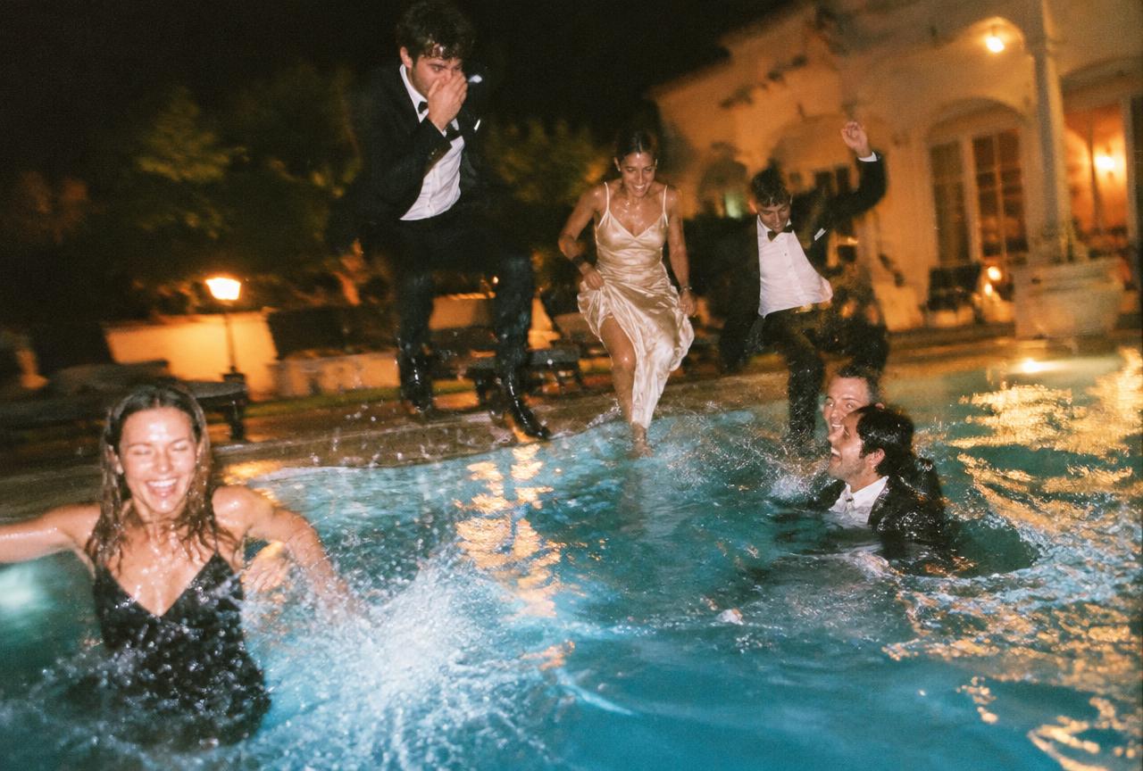 Guests in formalwear jumping into a pool
